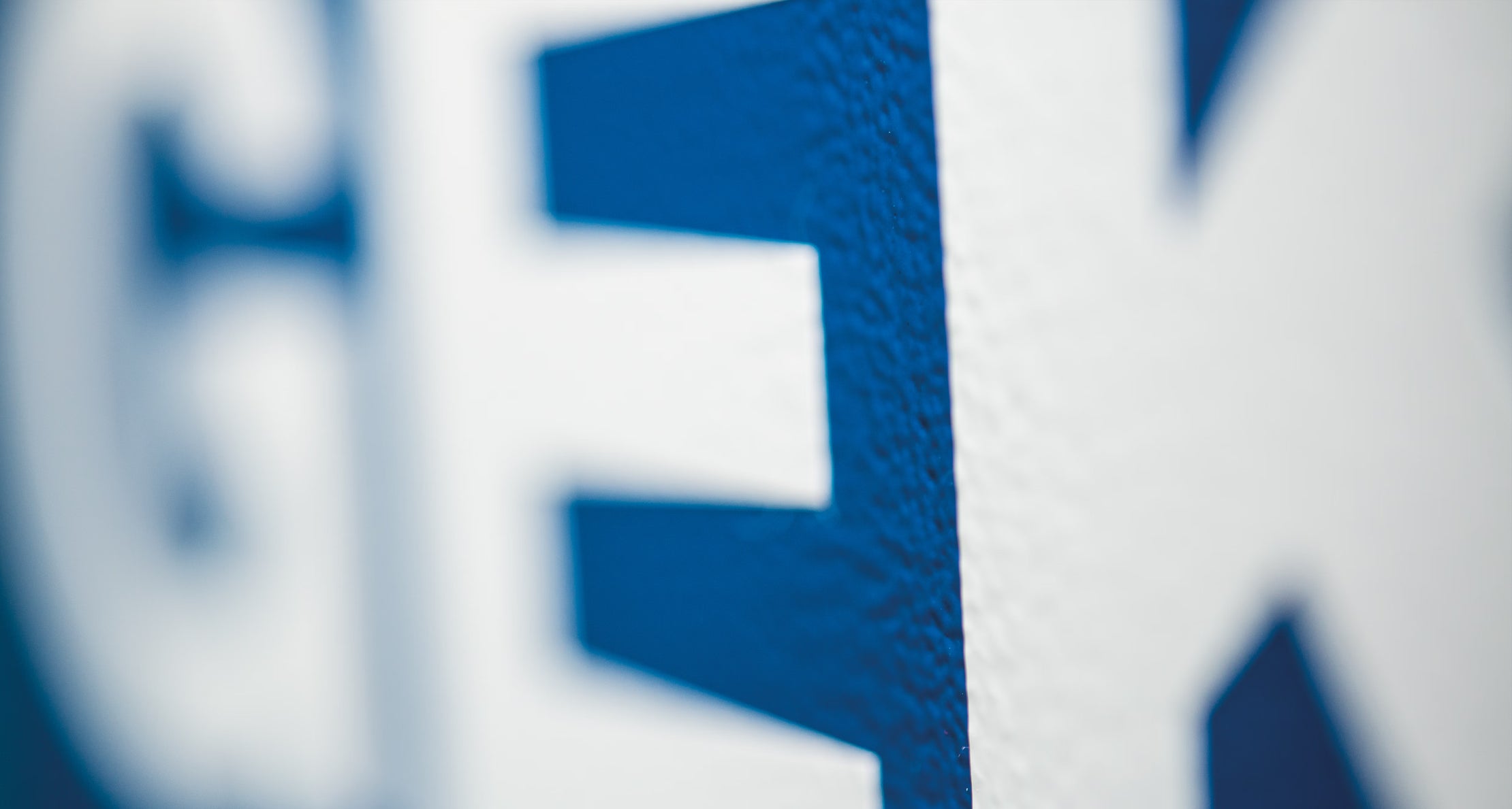 Close-up photo of a textured blue and white GEKO logo